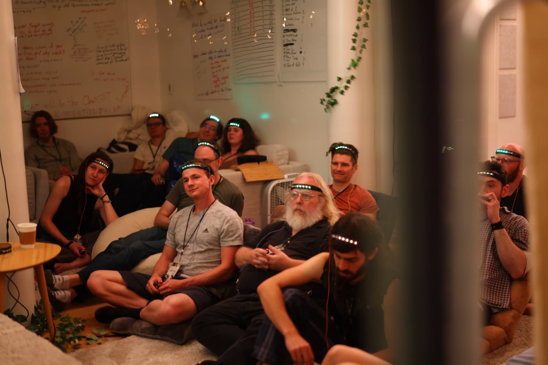 Attendees sit in a room wearing glowing headbands during a game-like session.